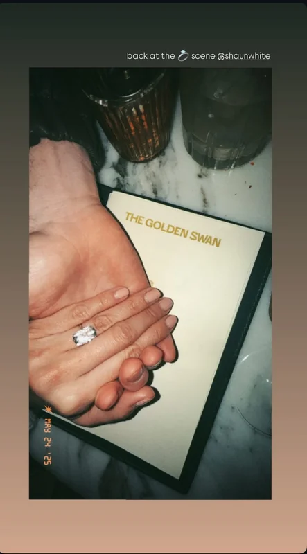 Close-up of Nina Dobrev engagement ring at a dining table.