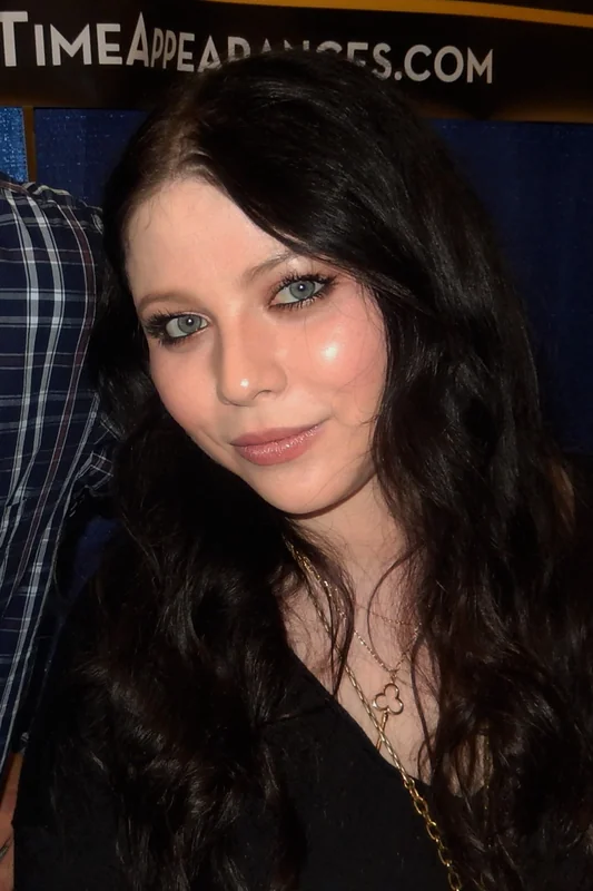 Michelle Trachtenberg smiling casually at an event