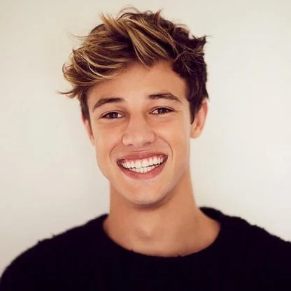 Cameron Dallas smiling warmly in a casual setting, relevant to his brand and net worth.