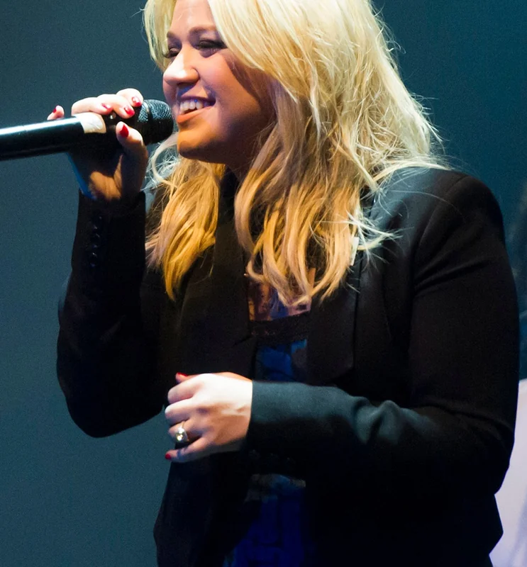 Kelly Clarkson passionately singing, showcasing her iconic songs.