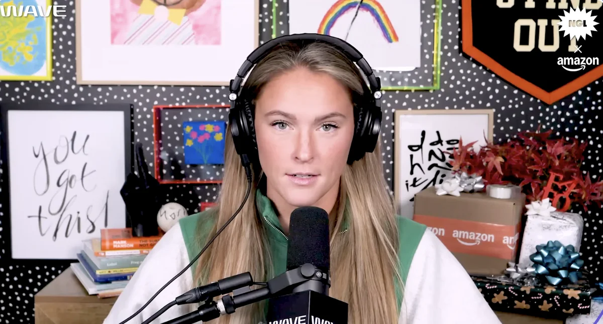 Kylie Kelce engaged in her Olympics gig, speaking into a microphone.