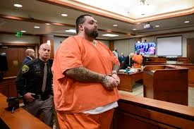 Carlos Jose Hernandez in court wearing an orange jumpsuit.