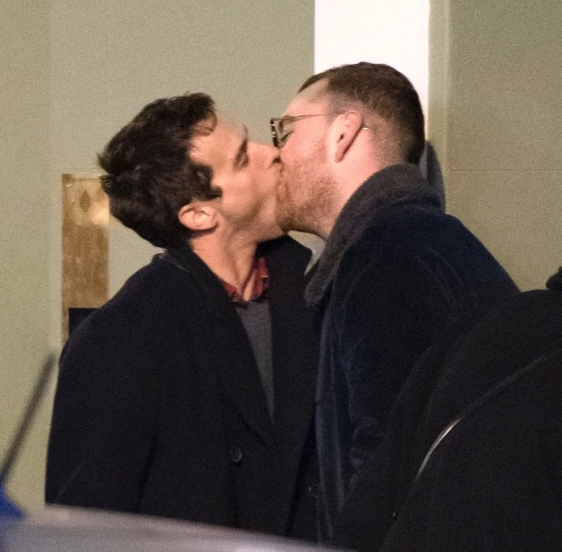 Brandon Flynn and Sam Smith kissing in a candid moment.