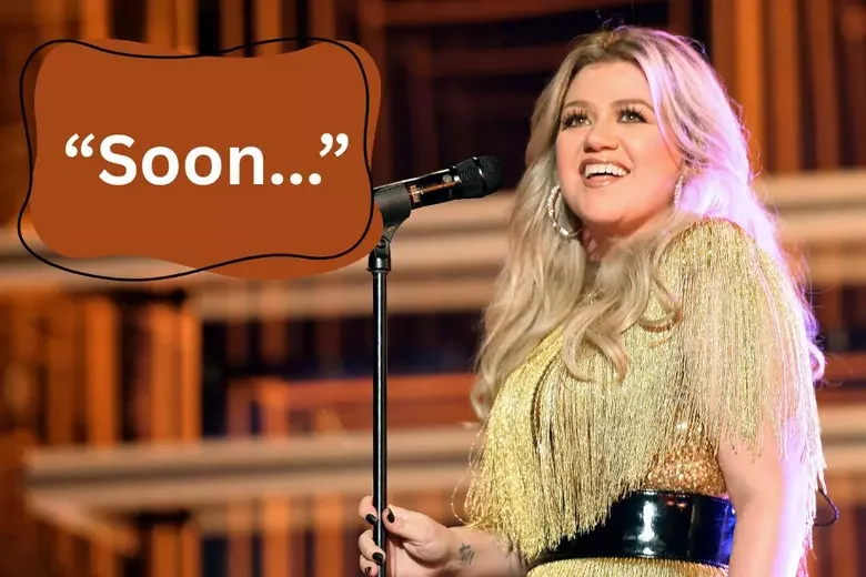 Kelly Clarkson teasing new songs with 'Soon...' on stage.