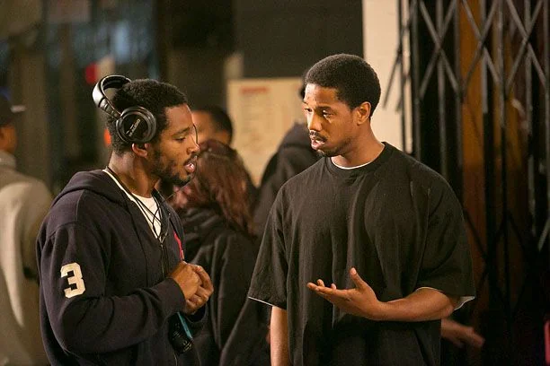 Michael B. Jordan collaborating with co-stars on set.