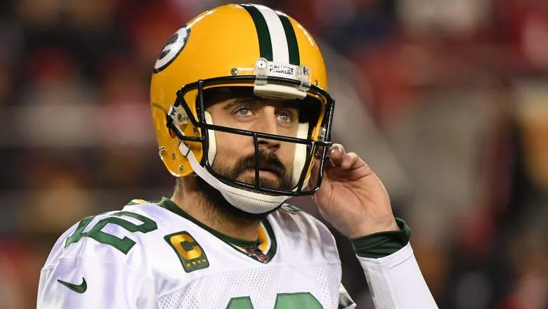 Aaron Rodgers in game uniform, reflecting on his religion and career.