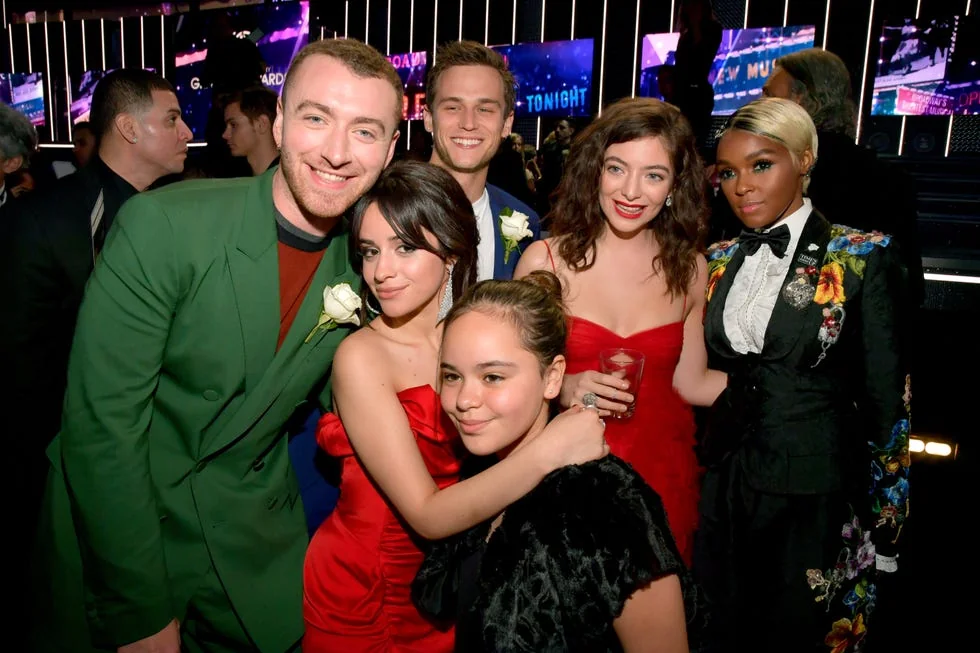 Brandon Flynn and Sam Smith with fellow celebrities at an event.