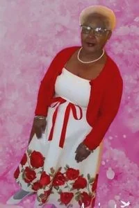 Elderly woman in floral dress reflecting heritage themes in Phyllis Stephens' art.