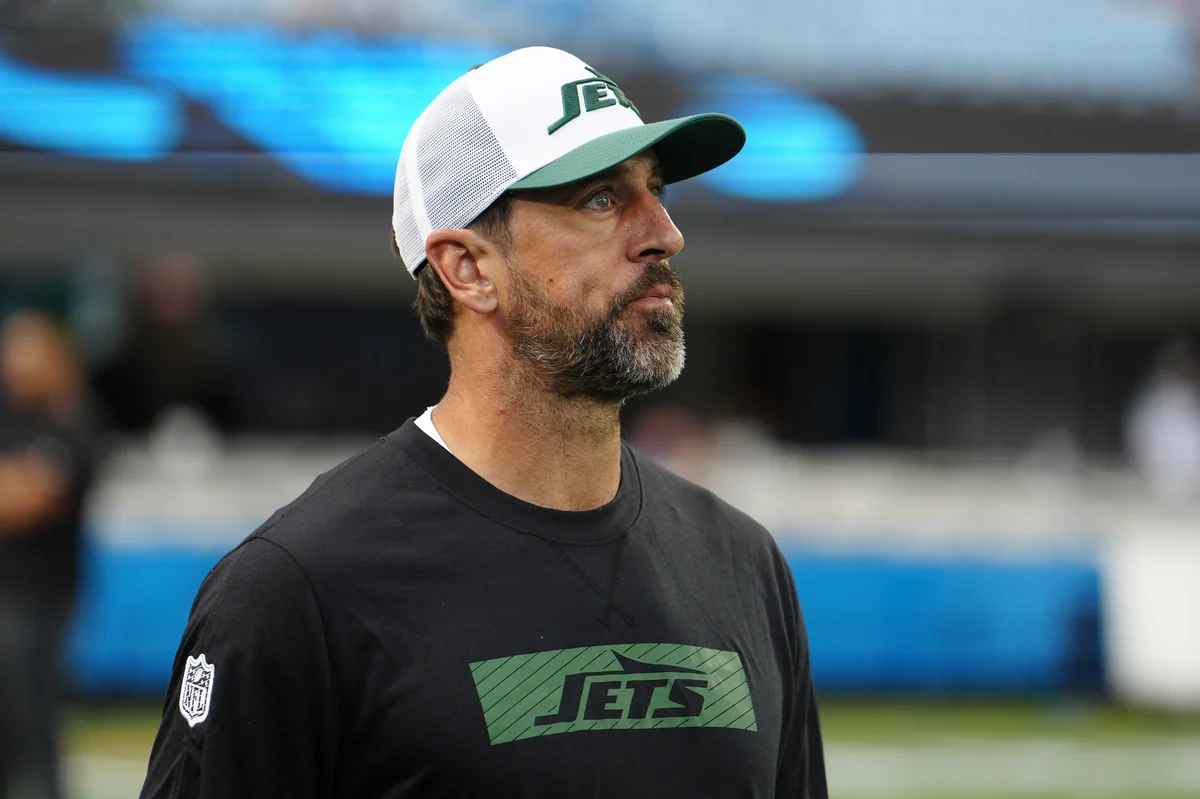 Aaron Rodgers in Jets gear, indicating a shift in career and personal beliefs.