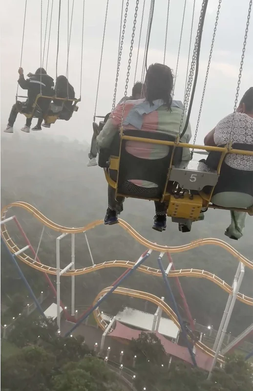 Swing ride view, emphasizing thrill and risks like 'died at Six Flags'.