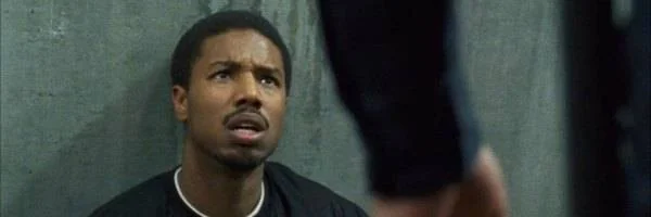 Michael B. Jordan expressing concern in a dramatic film scene.