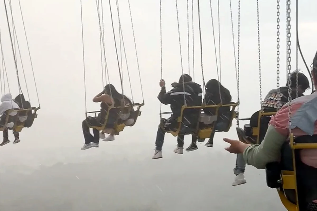 Swing ride during storm, highlighting risks like 'died at Six Flags'.