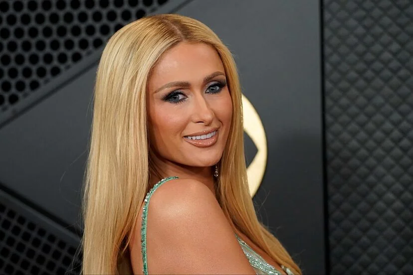 Paris Hilton smiling at an event, highlighting her celebrity status and net worth.