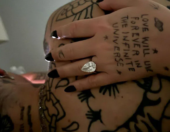 Close candid of Demi Lovato's hand and engagement ring with her tattoos visible